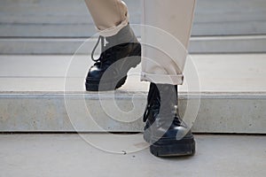 Detail of black boots of man walking down stairs