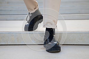 Detail of black boots of man walking down stairs