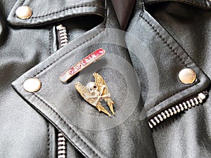 Detail of black leather classic biker jacket with metal badges