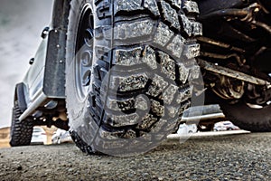 Detail of a black offroad tire on a offroad truck vehicle, built for dirty offroad roads