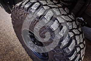 Detail of a black offroad tire on a offroad truck vehicle, built for dirty offroad roads