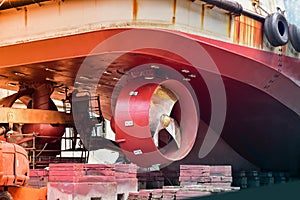 Detail of black stern and ship propeller, rudder red after maintenance already.