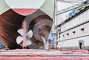 Detail of black stern and ship propeller, rudder in shipyard