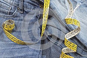 Detail of blue jeans with measuring tape.