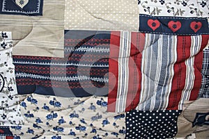 Detail of blue and red patchwork quilt with hand quilting