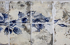 Detail of a blue rose on ceramic tiles wall from damaged facade of old house in Portugal