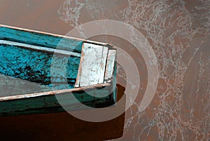 Detail of a blue canoe on a muddy river photo