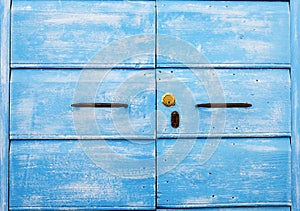 Detail of blue wooden door with ancient and new door lock - Old traditional blue wooden door and ancient iron handles - Typical