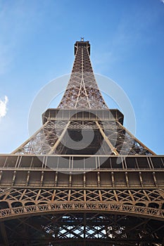 Detail bottom view of Eiffel Tower on the blue sky background in sunset light