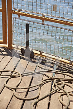 Detail of the bow of a tourist boat sailing, mooring rope on deck timbers