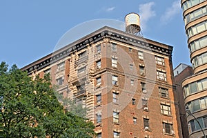 Detail of a brick apartment building with water  tower on the roof