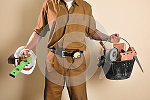 Detail of bricklayer holding tools and building materials  background