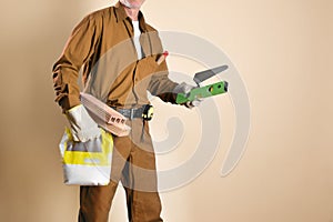 Detail of bricklayer holding tools and building materials