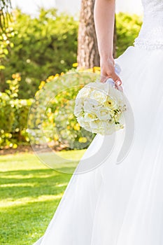 Detail of bride holds in hand a wedding bouquet of flowers in a garden