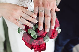 Detail of bride`s bouquet and hands holding