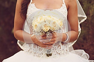 Detail of bride's roses bouquet and hands holding