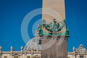 Detail of bronze lions holding the Egyptian Obelisk and the Basilica of St. Peter in the background in the Vatican photo