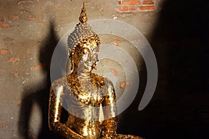 Detail of Buddha sculpture covered with offering of golden leaves at Wat Yai Chai Mongkhon, Thailand.