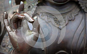 Detail of Buddha statue with Karana mudra hand position photo