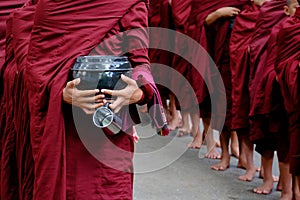 Detail of buddhist monks crowd and person holding a bowl and cup