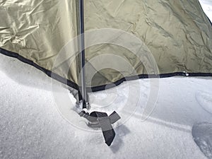 Detail of camping tent anchored in snow. Extreme winter trek