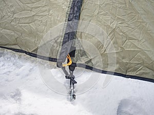 Detail of camping tent anchored in snow. Extreme winter trek