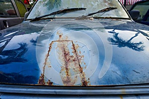 Detail of the car's front hood's cracked and rusted paint. Unbranded automobile that is rusted and broken photo