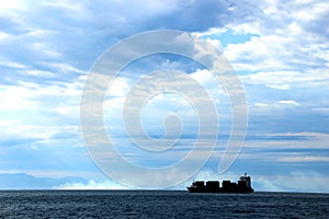 Detail of a cargo ship breezing through the Tyrrhenian sea teeming with clouds photo