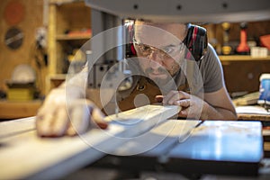 Detail of a carpenter intent on cutting a piece of wood with precision