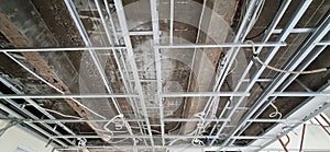 Detail of the ceiling structure in which there are hollow frames, cables, pipes, and beams which are still under renovation.