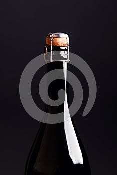 detail of champagne bottle with a cork on a black background