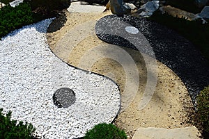 Detail of Chinese Yin and Yang symbol of contrary and complementary forces made as stone decoration with pathway in Mu-Shin garden