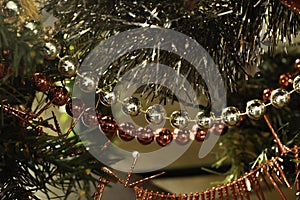 Detail of Christmas ornaments. Tinsel and pearl garlands in red and gold colors