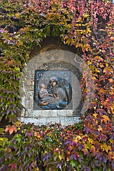 Detail from a church wall, Virgin Mary with Jesus Christ surrounded with autumn leaves at Kalemegdan, Belgrade