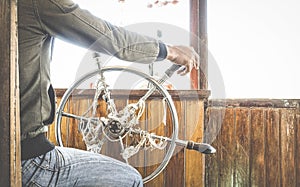 Detail close up of helmsman sailing and controlling helm wheel on river travel