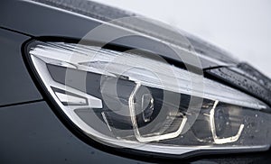 Detail close up view of the LED adaptive head light of a BMW sedan car.