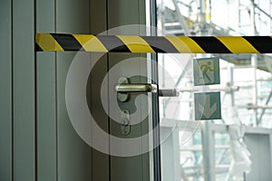 A detail of closed door and blocked with barrier tape to the terrace that is being reconstructed and covered with scaffolding and