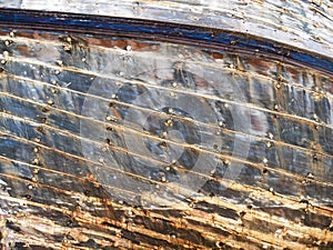 Detail and closeup of old and colored boat wooden hull, old painting with cracks and wood texture