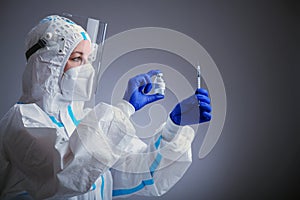 Detail closeup of syringe needle and ampoule , nurse taking injection shot,hands in blue protective gloves holding