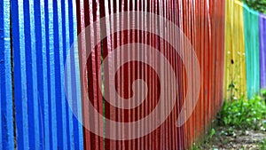 Detail and closeup view of a colorful wooden fence in different colors of the rainbow