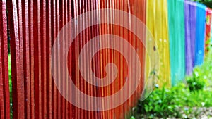 Detail and closeup view of a colorful wooden fence in different colors of the rainbow