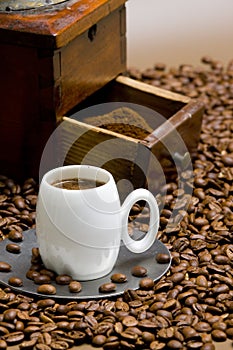 detail of coffee mill with coffee beans and cup of coffee