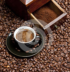 detail of coffee mill with coffee beans and cup of coffee