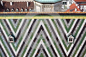 Detail of Colorful Tiles and two Small Window on Roof of the Saint Stephansdom Cathedral in Vienna, Austria.