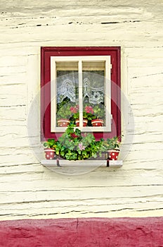 Detail of colorful window with flowers on old traditional house