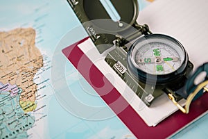 Detail of a compass camera and a notebook on a world map. Adventure travel concept. Copy-space