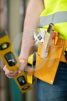 Detail Of Construction Worker On Building Site Wearing Tool Belt