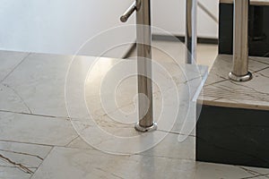 The detail of the corner baseboard on the wall and granite tiles on the floor. A white wall with a copy space, decorated with