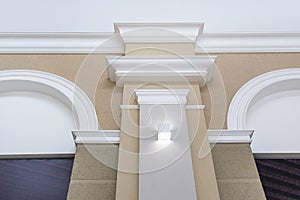 Detail of corner ceiling with intricate crown molding on column with spot light