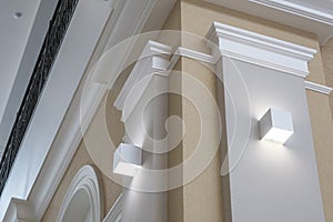 Detail of corner ceiling with intricate crown molding on column with spot light